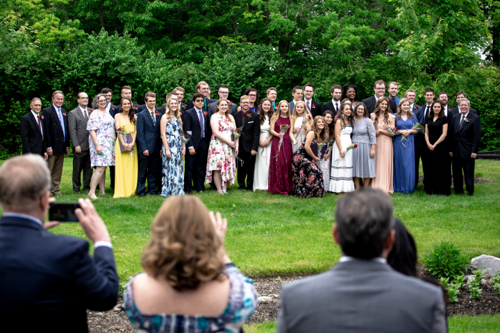 The class of 2019 smiles for a group photo with faculty after the graduation ceremony.