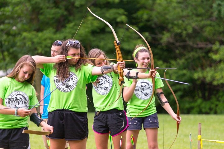 A girls dorm taking part in archery. 