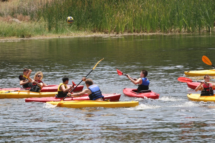 Campers kayak down the river. 
