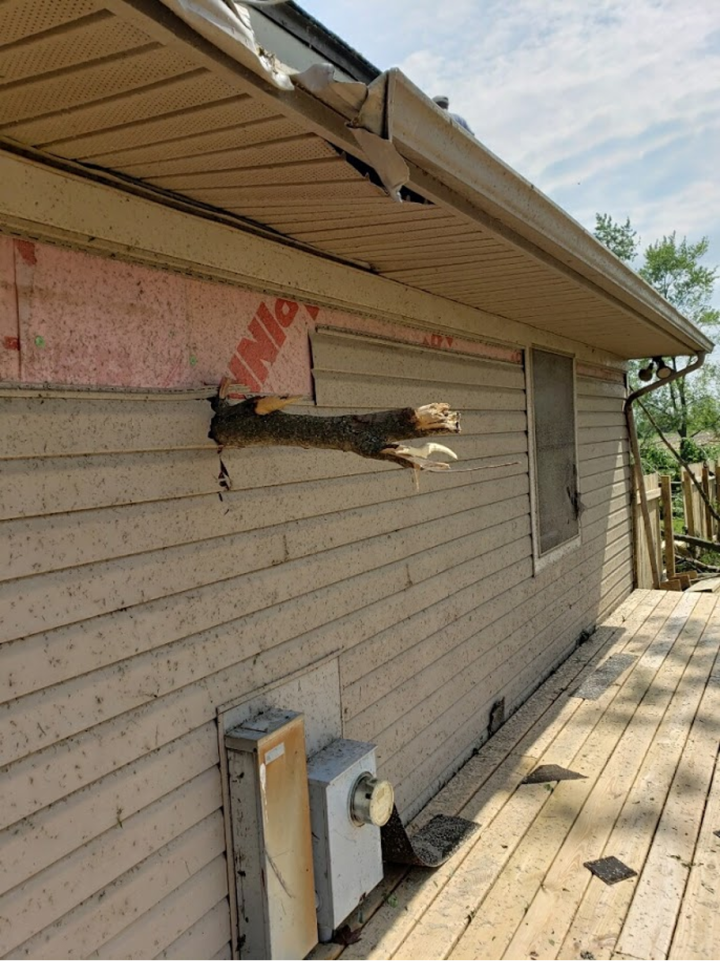 A tree branch punctures a Dayton home.