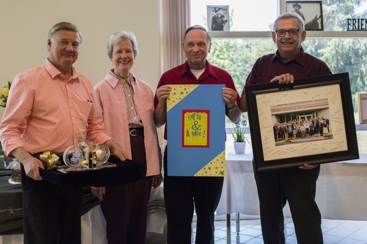 Peter Eddington, Media and Communications Services manager and Victor Kubik, president, award the Surratts with a card, keepsake bookends, and a photo of all home office employees that was also signed by employees.