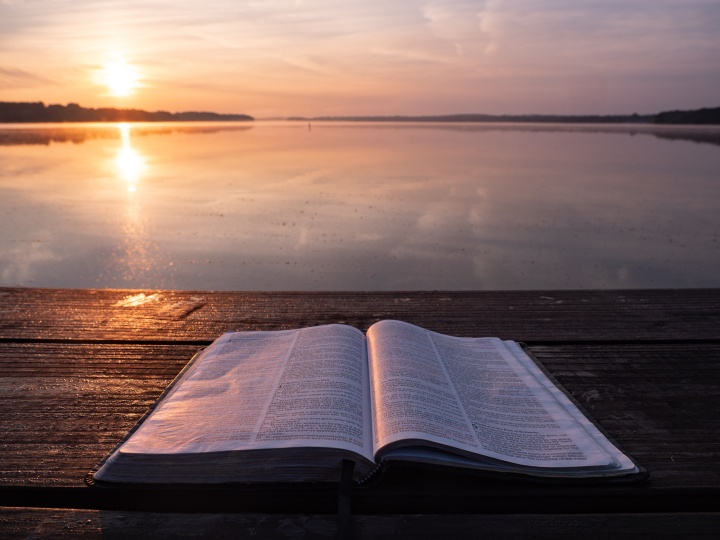 An open Bible laying on a table.