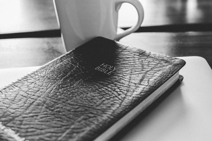 Bible and coffee mug on a table.