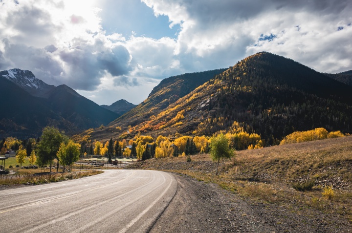 A road leading into a landscape of fall foliage