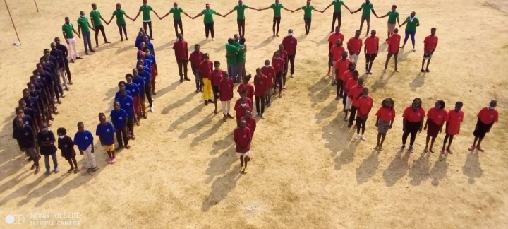 Photo of the youth at the camp in Zambia forming a UYC sign.