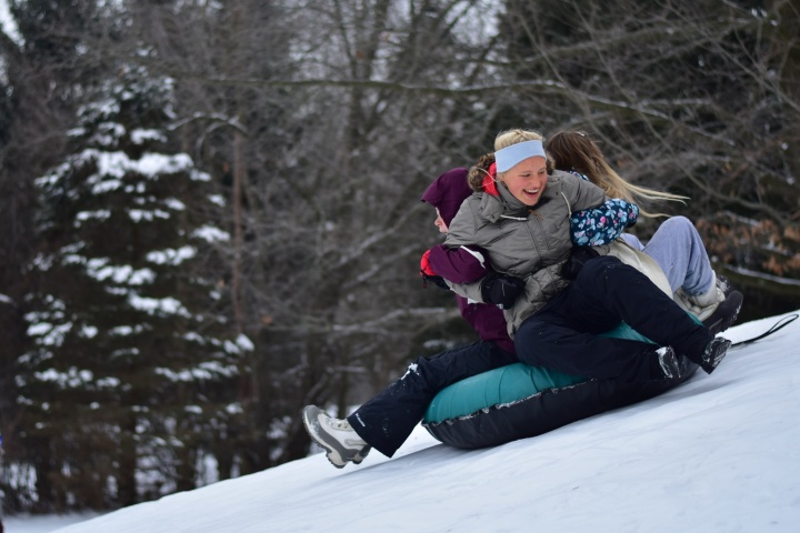 a group of girls snow tubing