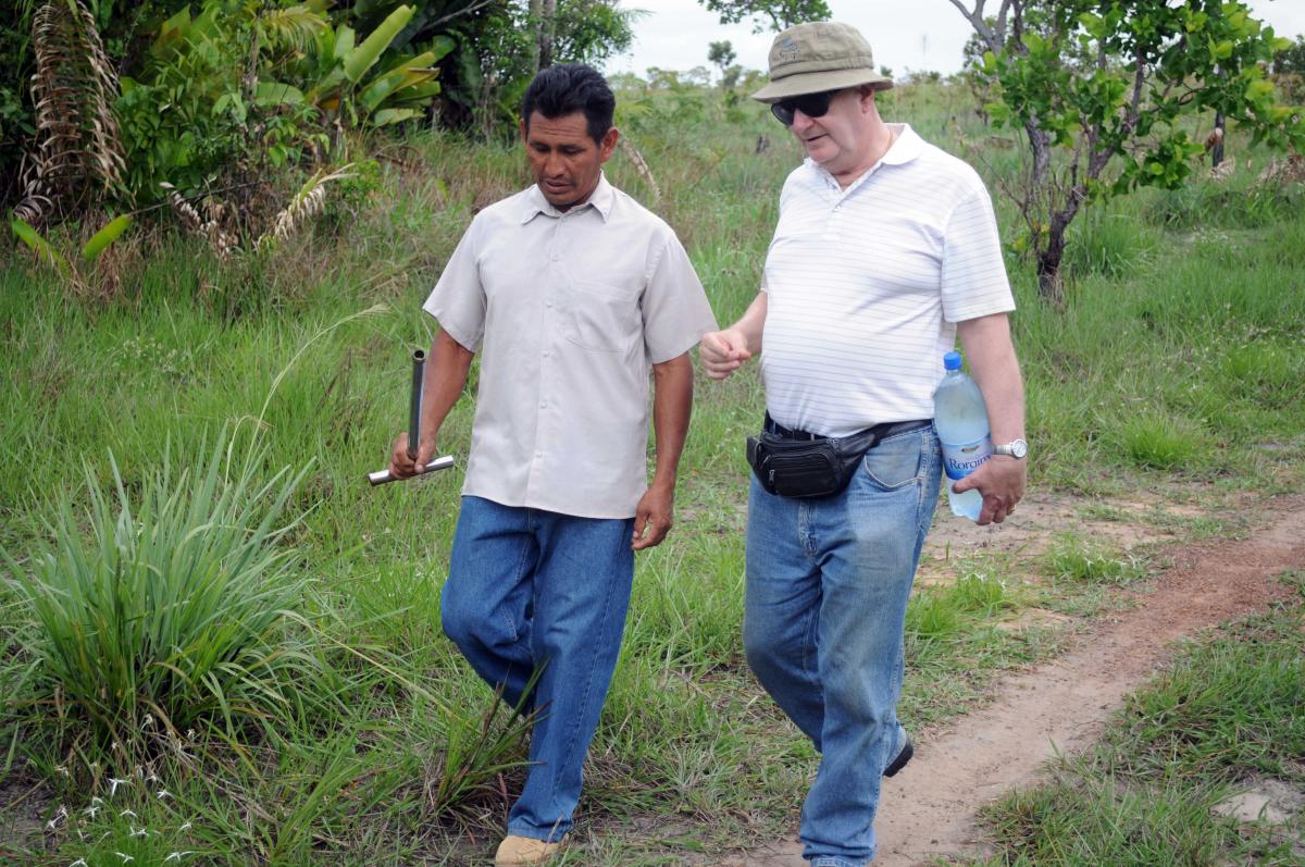 Jorge de Campos walks to a cassava field through the jungle with deacon Benedito