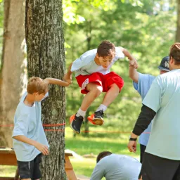 a boy jumping over a rope