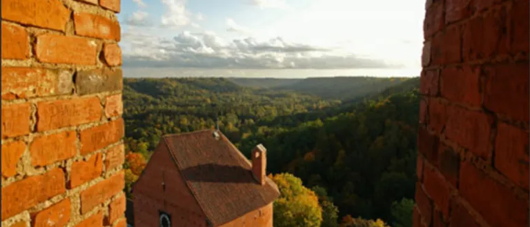 Photo through a brick window overlooking a valley
