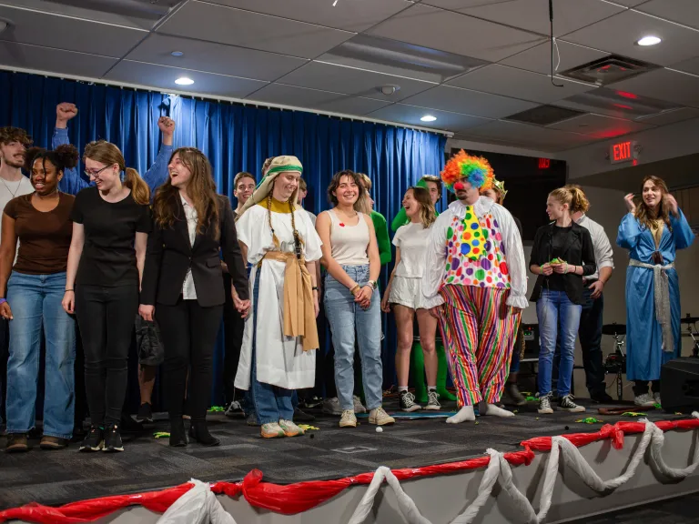 More than 100 church members attended the ABC Charity Auction. a group of young adults wearing costumes standing on a stage