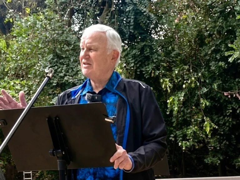 Man standing and speaking behind a podium