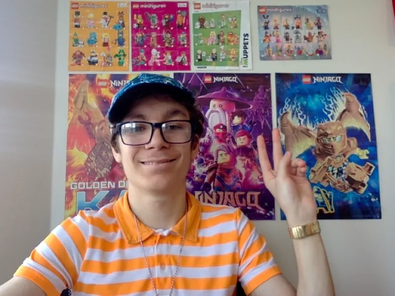 a teenage boy sitting in front of several movie posters