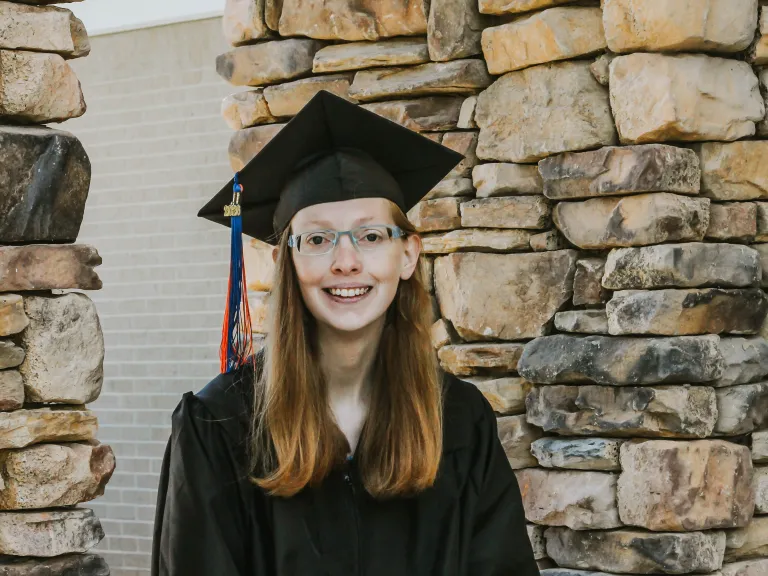 a young woman wearing a graduation cap and robe
