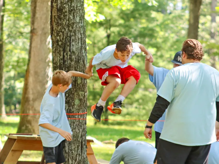 a boy jumping over a rope