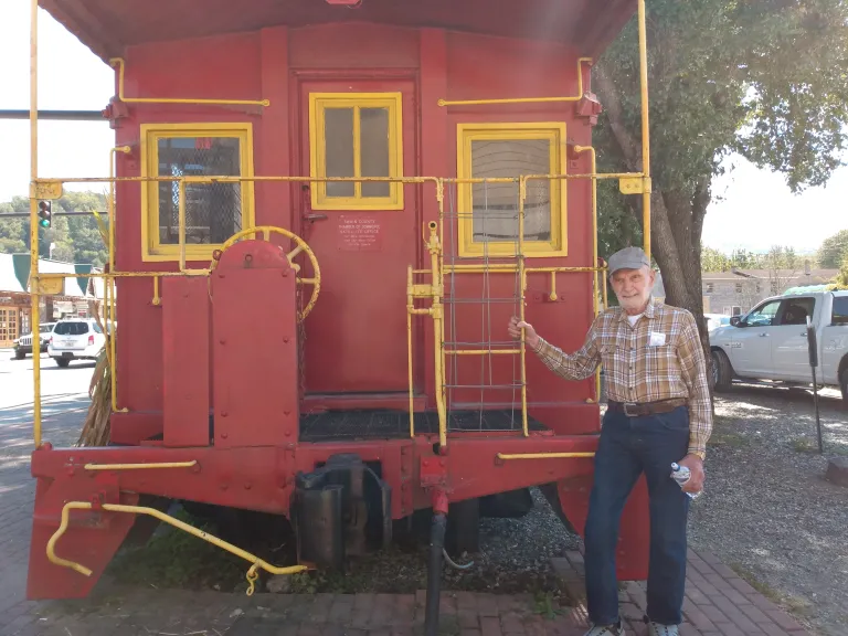 a man standing in front of a train caboose