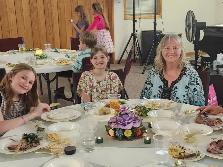 Seated left to right: Randy Hooser, Riley Hooser, Leah Rowin, Laura Fenger, Samantha Clark, Natalie Hooser. People seated around a table for a meal