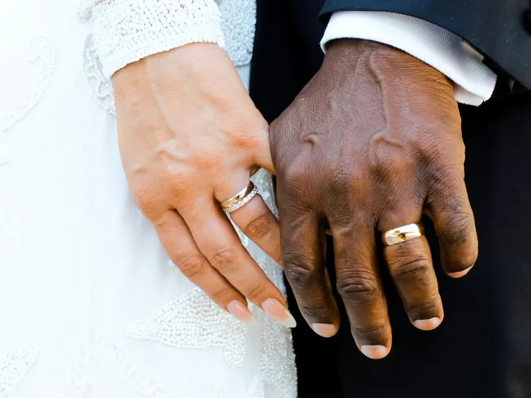 a pair of hands with wedding rings
