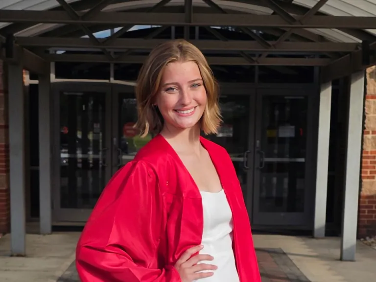 a young woman wearing a red graduation robe