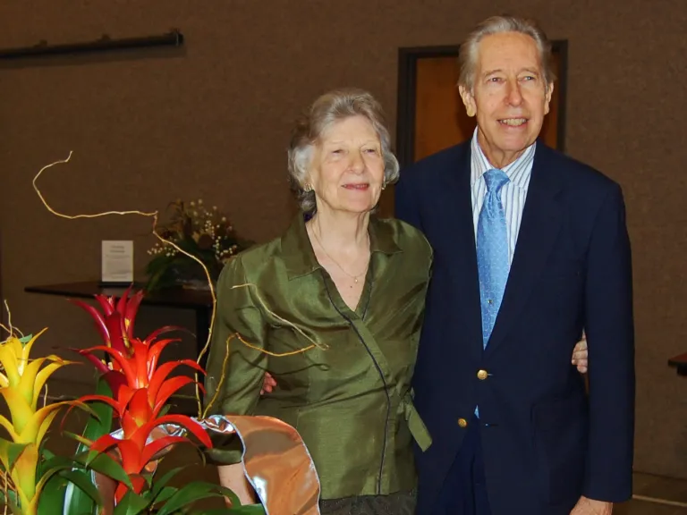 Jim and Mary Beth Philp a couple standing behind a table with flowers