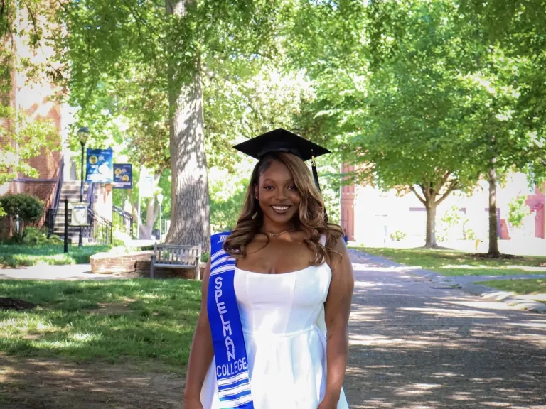 a woman wearing a graduation cap and standing outdoors
