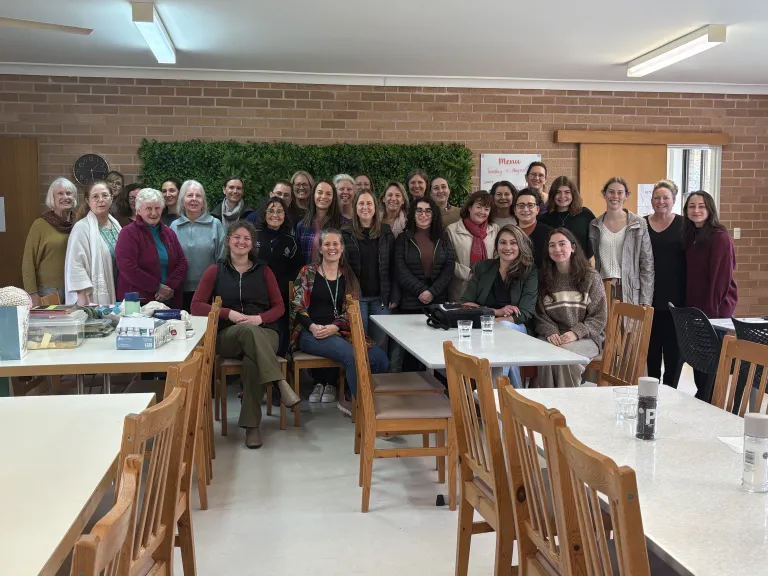 a large group of women standing in a room with tables