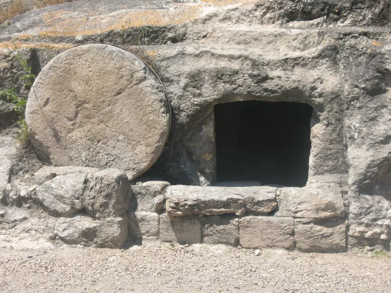 a stone tomb with the covering stone rolled aside