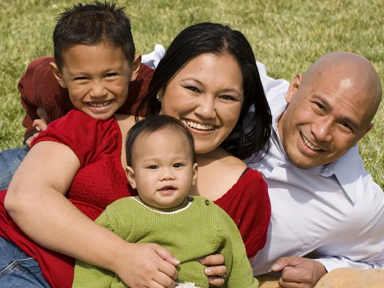 Children need training and instruction from parents in how to live in harmony with God’s laws of love. A family lying down on a blanket.