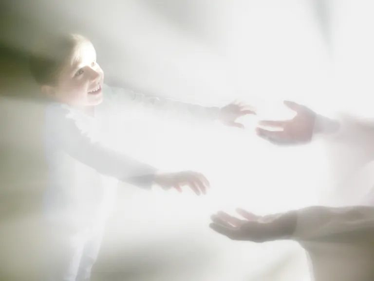 For many the most important aspect of heaven is the opportunity to see their loved ones again. A photo illustration showing a person reaching for another person surrounded by bright lights.