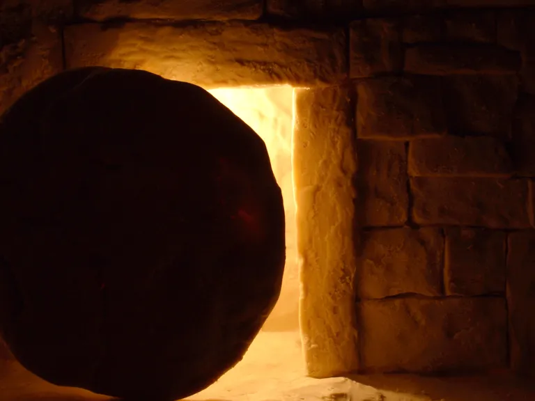 A round stone in front of a tomb entrance.