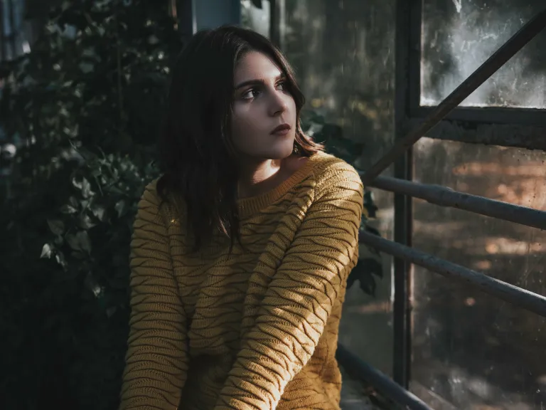 A young woman looking out a window.