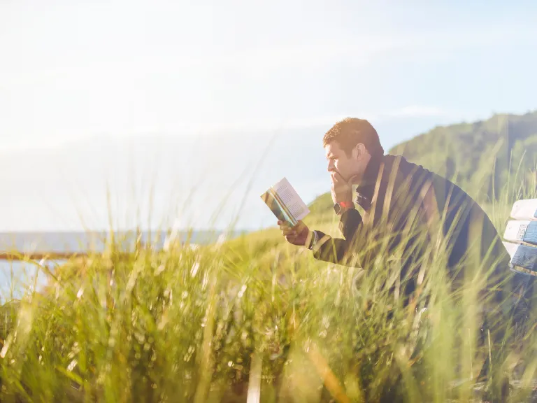 To know what God says to us, we must read the Bible, God’s revealed words to man. It tells us how He wants us to live. A man sitting on a bench.