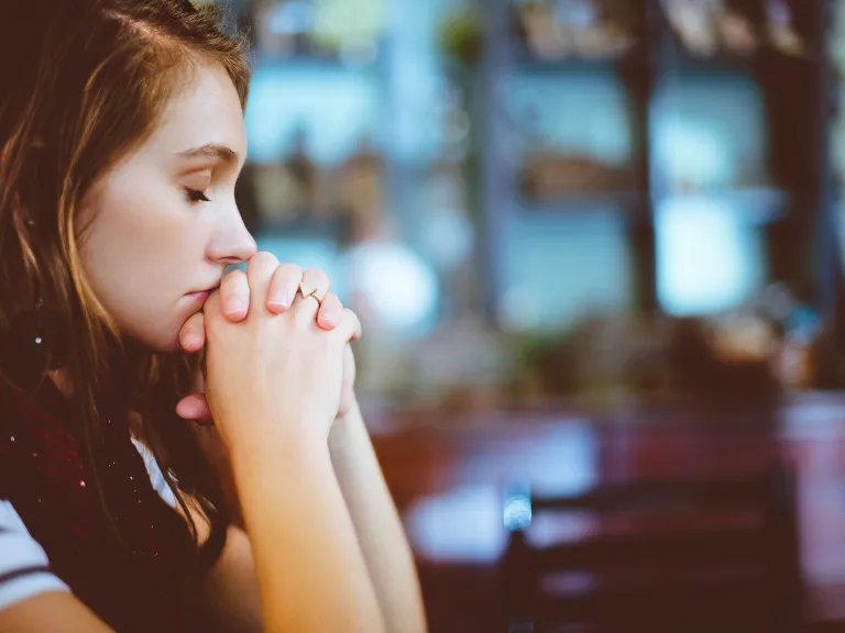 A young woman praying.