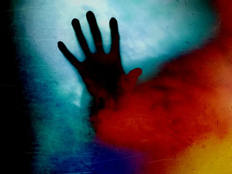 Une illustration de la photo d'une main à travers la fumée rouge.