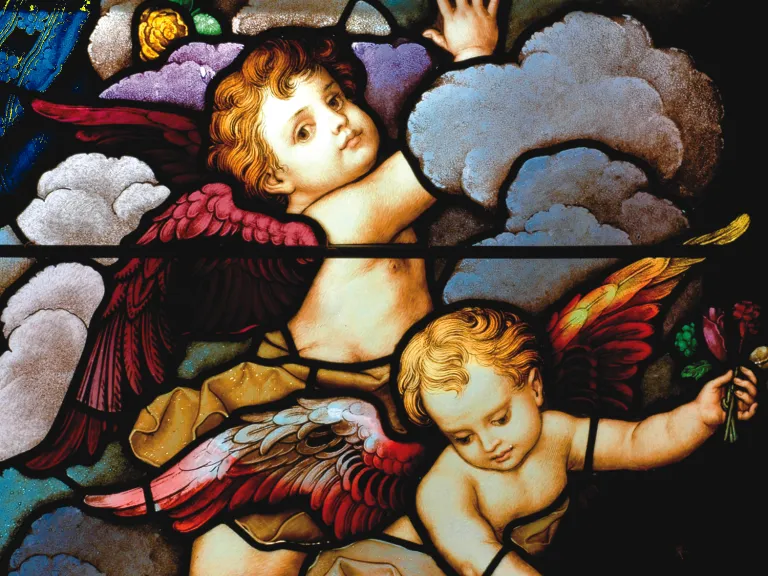 Stained glass close-up of two cherubic angels in the sky