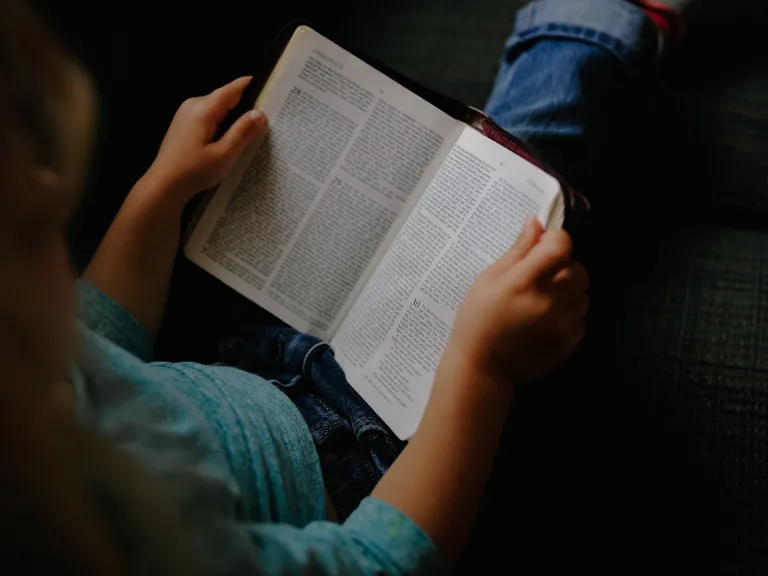 Fasting is for one's spiritual health, which involves abstaining from food and drink while spending a lot of extra time in prayer and Bible study. A person reading a Bible.