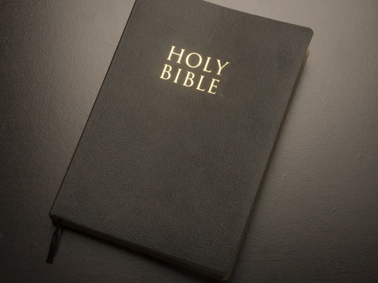 The “living God” is a description used in both the Old Testament and New Testament to distinguish the true God, who is real and alive. A Bible on a table.