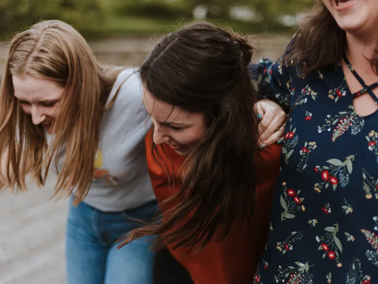 Being a true friend means being there when everything is crumbling as well as when things are going well. We do not walk away when times get tough. A group of young women laughing.