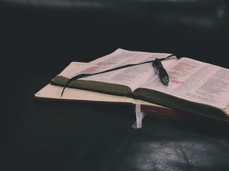 God doesn’t change in the way He thinks and deals with people, neither does His law change. An open Bible and notebook laying on a table.