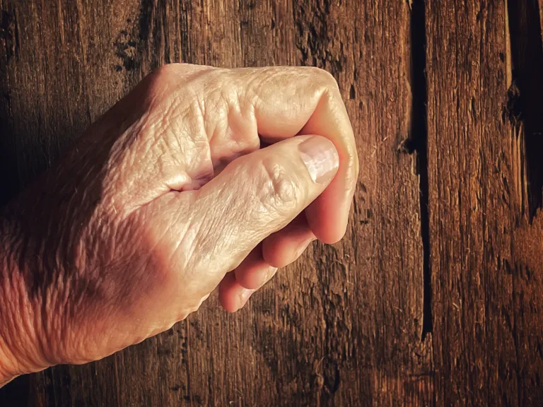 For those Christians who are neglectful, Christ will knock at the door of their hearts to be let in. An old hand knocking on a old wooden door.