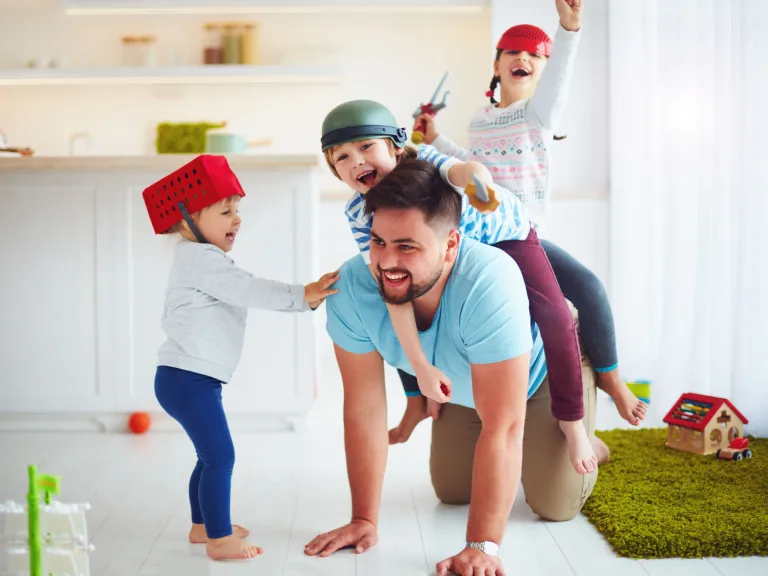A dad playing with his kids.