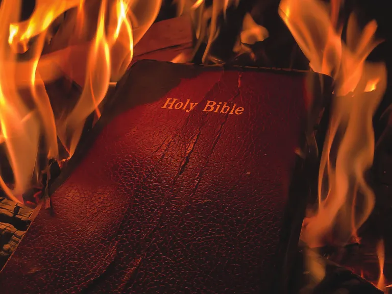 When people ”cancel God” by forsaking Him, they cut themselves off from the only source of true values and are left flailing in blind ignorance and suffering. A burning Bible.