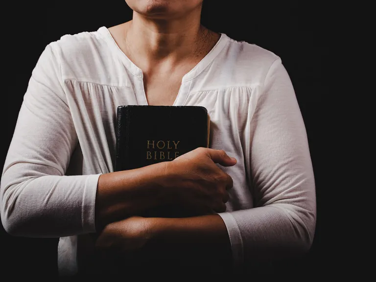 A woman holding a Bible.