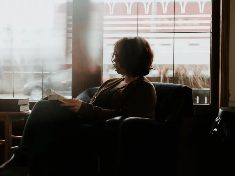 It is helpful to take some time to reflect on exactly why God wants us to love our enemies, and how it is beneficial. If we can see the good that can come out of it, we may feel more motivation to do what we need to do. A woman sitting in a chair looking at a book.