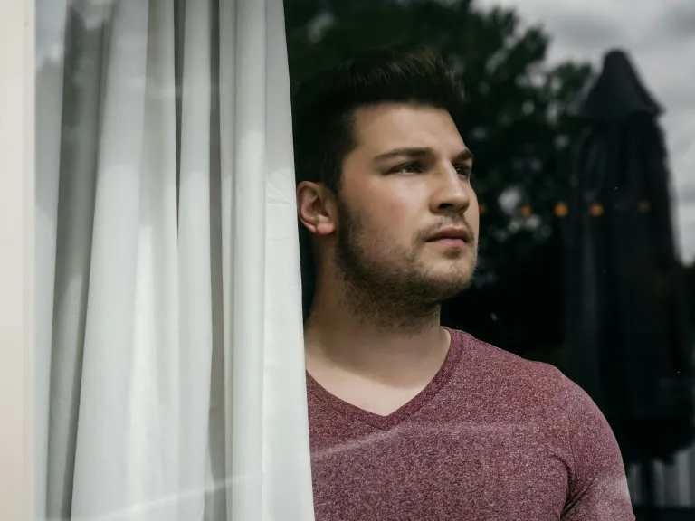 a man looking out a window into the distance