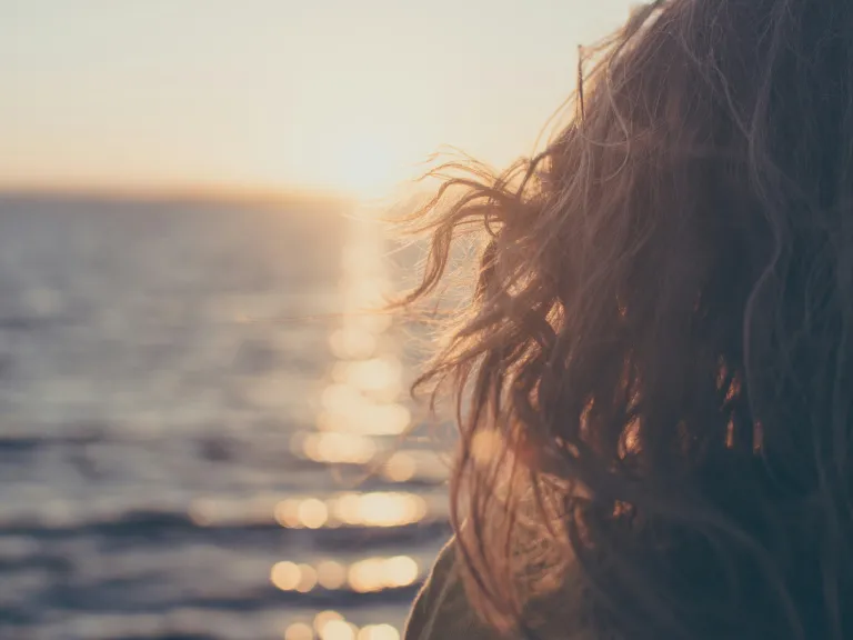 Knowing God is on our side and trusting Him to lead us is the way to achieve a truly positive outlook. A woman looking out on the ocean.