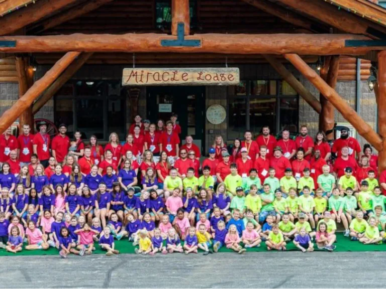 Camp Ironwood a large group of people, mostly children, with matching shirts standing outside
