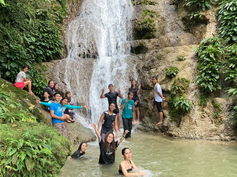 Young adults strengthened bonds during a waterfall hike.