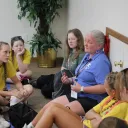 a group of teenage girls and a woman sitting in a circle