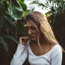 a sad woman surrounded by greenery