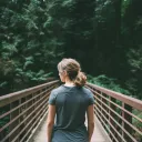 a woman on a bridge looking over the railing